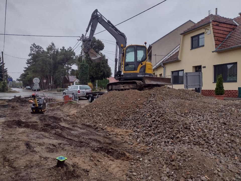 Bagr při zemních pracích u rodinných domů